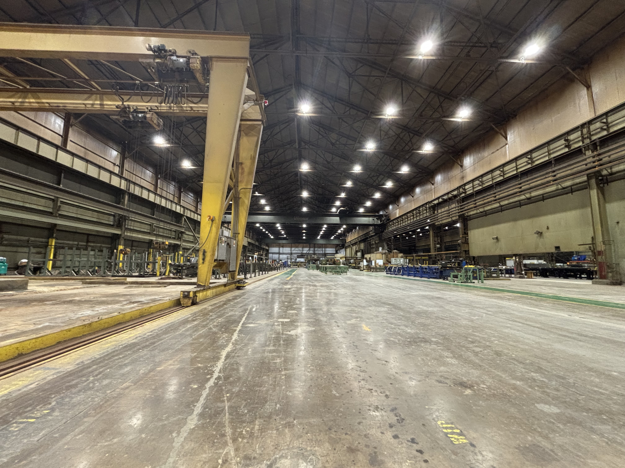 Wide interior view of the Nexteel USA mill, showing overhead cranes and equipment.